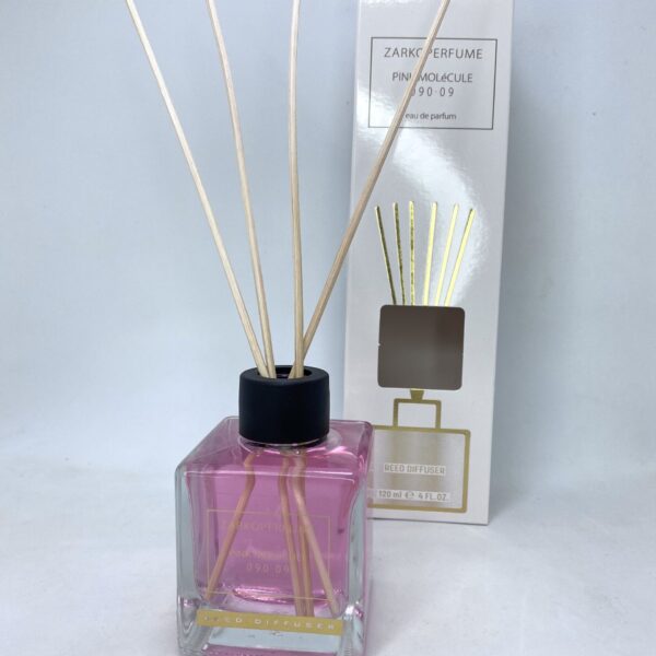 Reed diffuser with pink liquid and natural sticks for home fragrance.